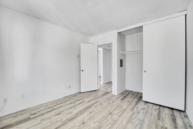 unfurnished bedroom with light wood-type flooring and a closet