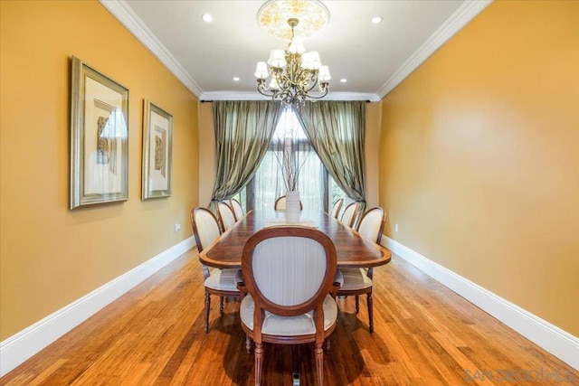 dining room with crown molding, wood-type flooring, and a notable chandelier