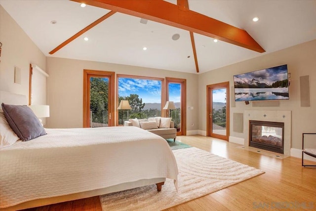 bedroom with access to outside, light hardwood / wood-style flooring, and lofted ceiling