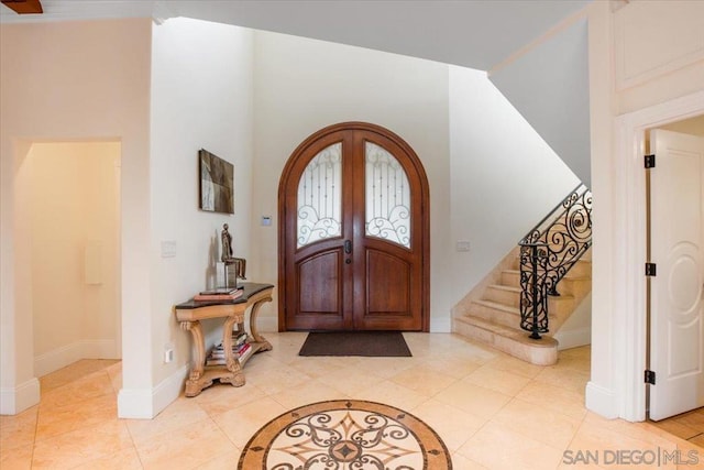 entrance foyer featuring light tile patterned floors and french doors