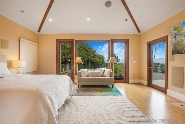 bedroom with access to exterior, vaulted ceiling, and multiple windows