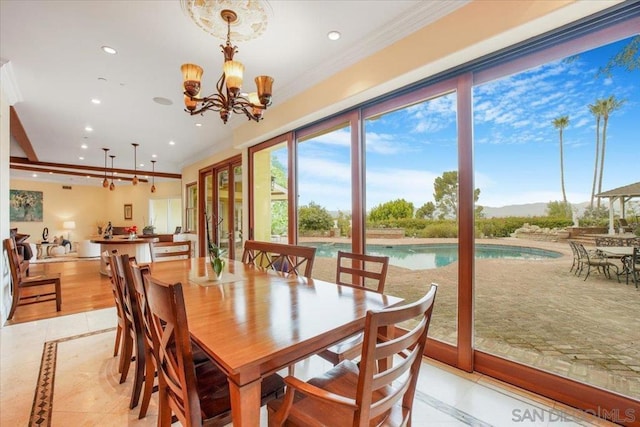 dining space featuring light tile patterned flooring, ornamental molding, and a chandelier