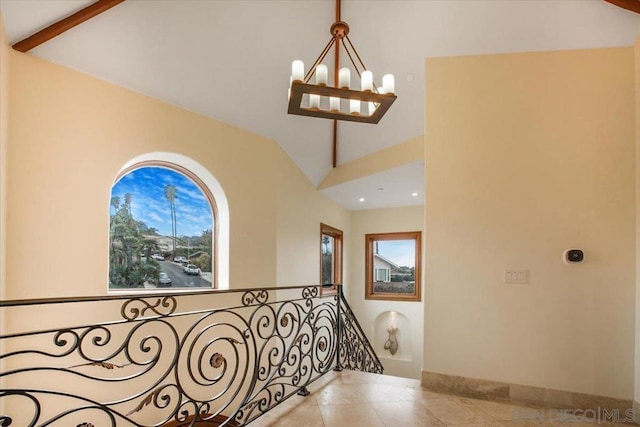 corridor with tile patterned flooring, vaulted ceiling, and a notable chandelier