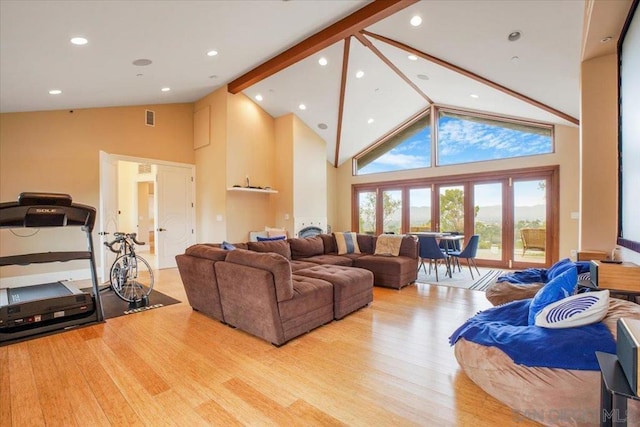 living room featuring beamed ceiling, light hardwood / wood-style floors, and high vaulted ceiling