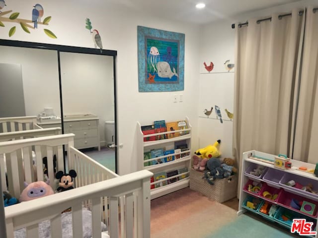 carpeted bedroom with a nursery area