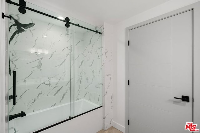 bathroom featuring bath / shower combo with glass door