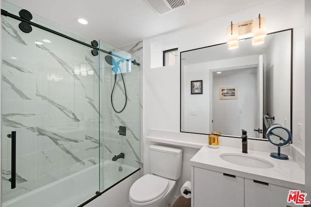 full bathroom with combined bath / shower with glass door, vanity, and toilet