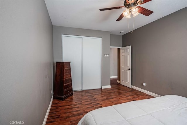 bedroom with a closet, baseboards, wood finished floors, and a ceiling fan