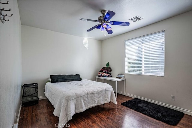 bedroom featuring ceiling fan, visible vents, baseboards, and wood finished floors