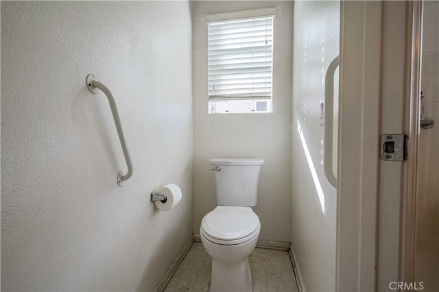 bathroom with baseboards and toilet