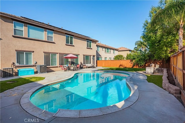 view of pool featuring a patio, central AC unit, and a fenced backyard