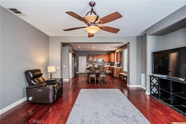 living area with visible vents, baseboards, and dark wood-style floors