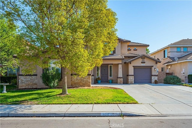 obstructed view of property featuring concrete driveway, a front yard, stucco siding, a garage, and stone siding