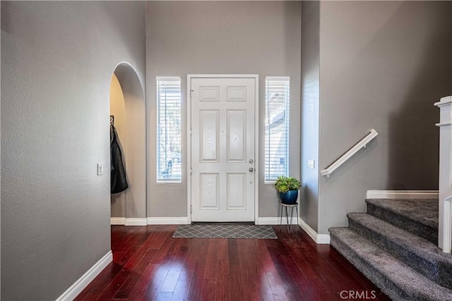 foyer with baseboards, stairs, and hardwood / wood-style flooring