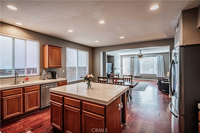 kitchen featuring dark wood-type flooring, a sink, recessed lighting, stainless steel appliances, and tile countertops