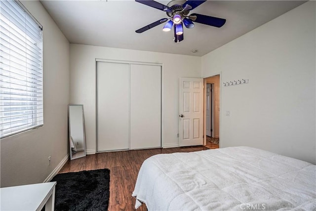 bedroom featuring a ceiling fan, wood finished floors, a closet, and baseboards