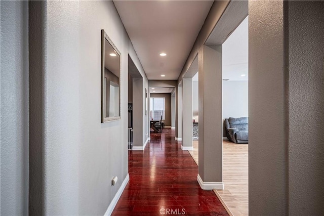 hallway with recessed lighting, wood finished floors, and baseboards