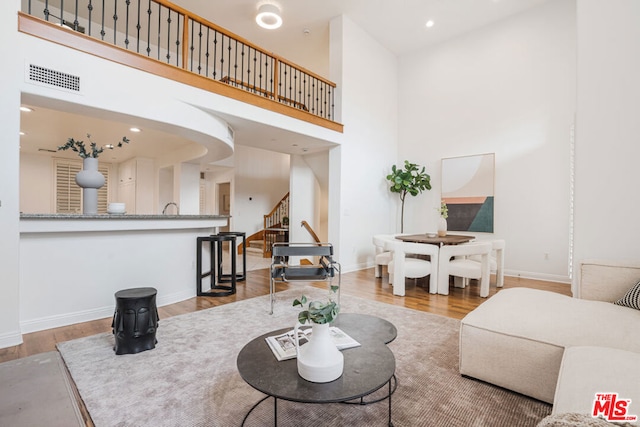 living room featuring hardwood / wood-style floors and a towering ceiling