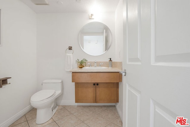 bathroom featuring tile patterned flooring, vanity, and toilet