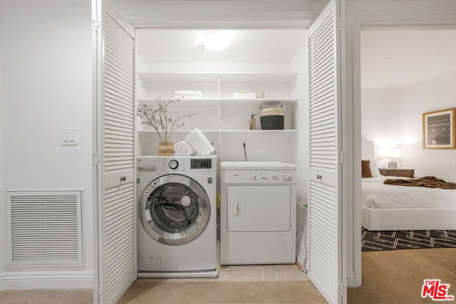 laundry room with light carpet and washing machine and clothes dryer