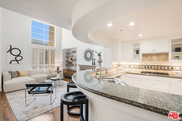 kitchen with hardwood / wood-style floors, white cabinets, and stainless steel gas cooktop