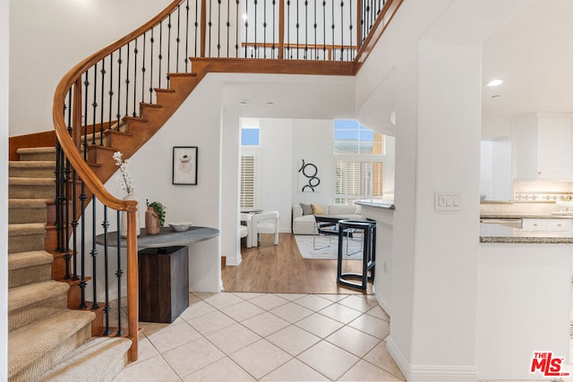 entrance foyer with a towering ceiling and light hardwood / wood-style floors