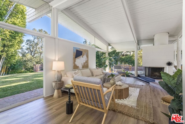 sunroom featuring vaulted ceiling with beams