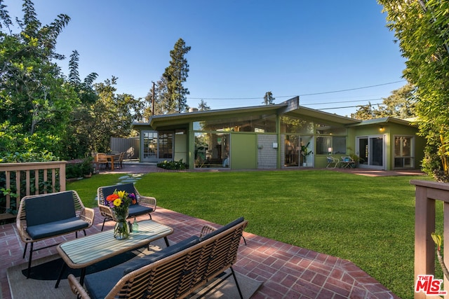 back of house featuring a yard, a patio, and an outdoor hangout area