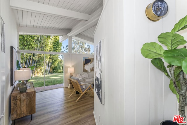 sunroom / solarium featuring vaulted ceiling with beams