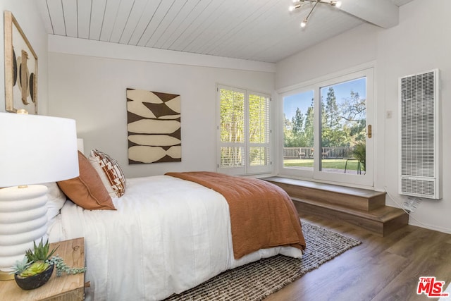 bedroom with hardwood / wood-style flooring, a chandelier, beamed ceiling, and multiple windows