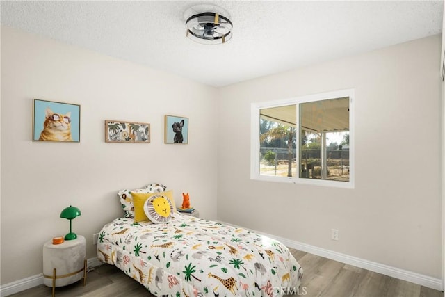 bedroom featuring wood-type flooring and a textured ceiling