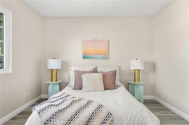 bedroom with hardwood / wood-style floors and a textured ceiling