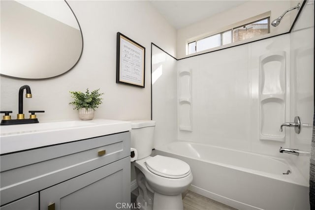 full bathroom with hardwood / wood-style floors, vanity, toilet, and shower / washtub combination