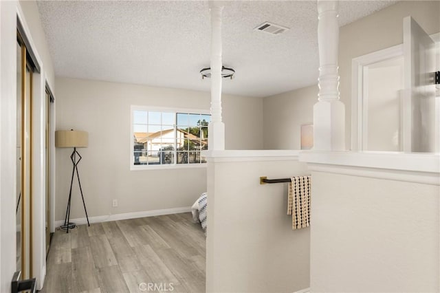 interior space with light hardwood / wood-style floors and a textured ceiling