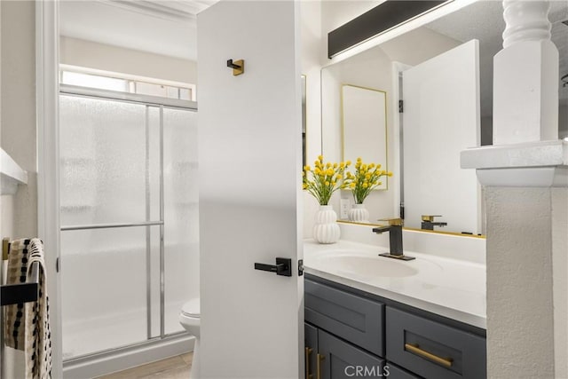 bathroom featuring hardwood / wood-style floors, vanity, toilet, and a shower with door