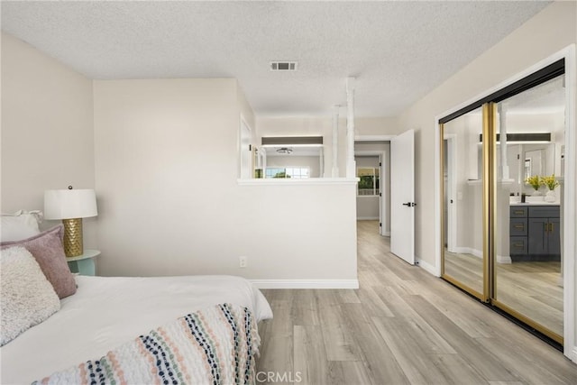 bedroom with a textured ceiling and light wood-type flooring