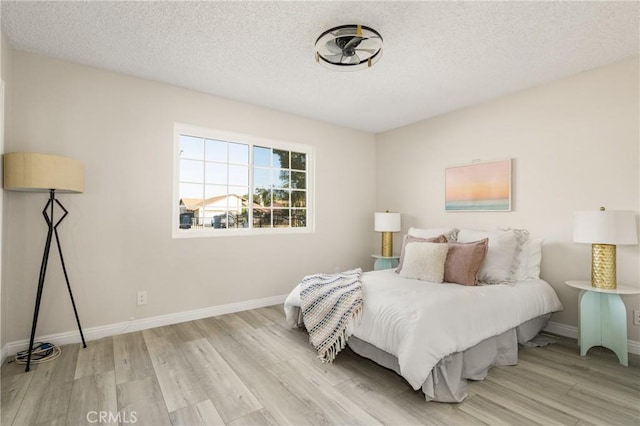 bedroom featuring light hardwood / wood-style floors and a textured ceiling