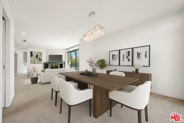 carpeted dining space with a chandelier