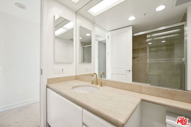 bathroom with vanity and a shower with shower door