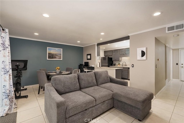 tiled living room featuring sink and crown molding