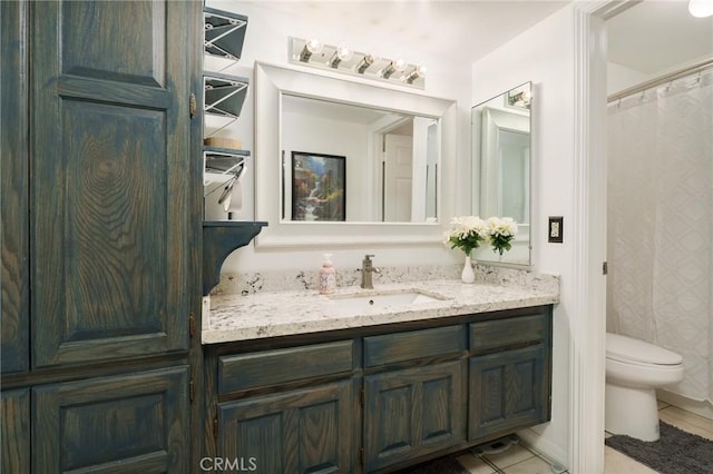 bathroom with tile patterned flooring, vanity, and toilet