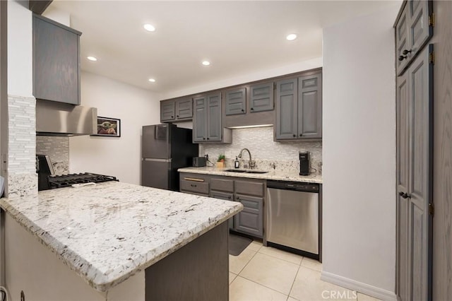 kitchen with kitchen peninsula, appliances with stainless steel finishes, decorative backsplash, and sink