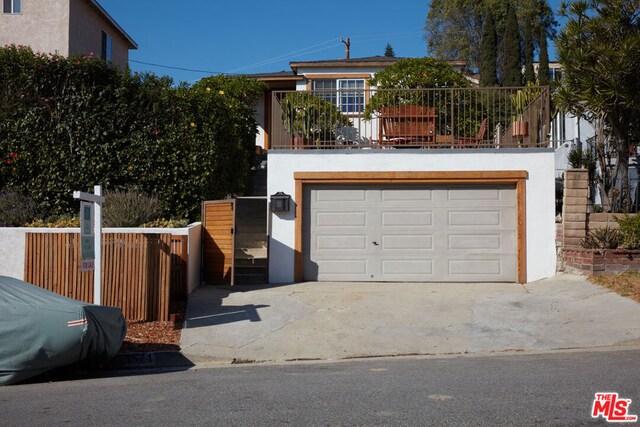 view of front facade with a garage and a balcony