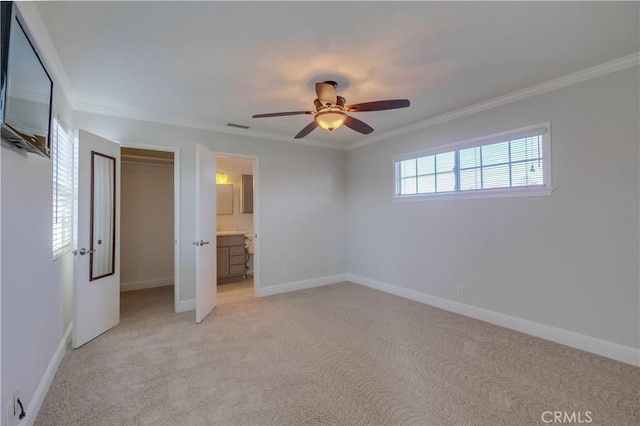 unfurnished bedroom featuring ensuite bath, ceiling fan, light carpet, a closet, and ornamental molding