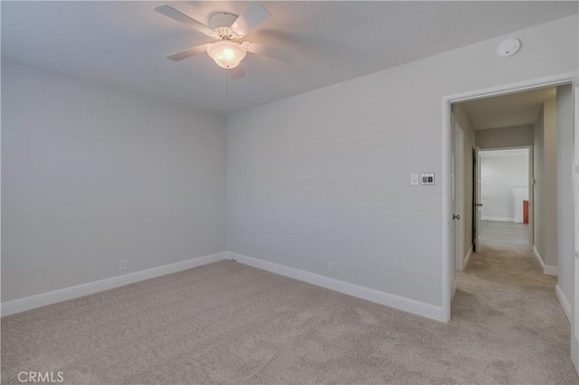 empty room featuring light colored carpet and ceiling fan