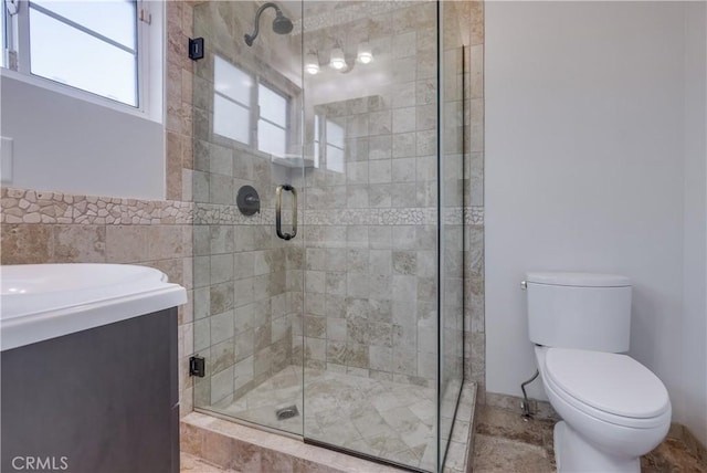 bathroom with a shower with shower door and toilet