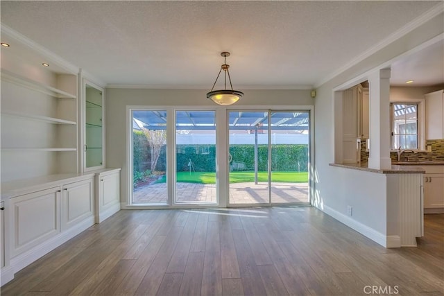 unfurnished dining area featuring light hardwood / wood-style floors, built in features, and a wealth of natural light