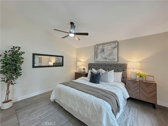 bedroom with ceiling fan, dark wood-type flooring, and vaulted ceiling