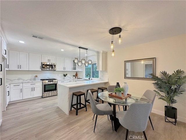 dining room with light hardwood / wood-style flooring and sink