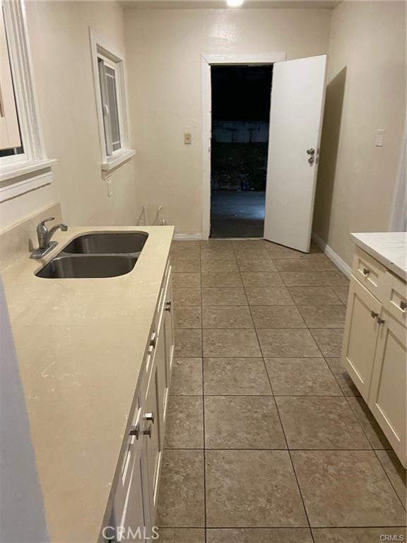 kitchen featuring white cabinets, sink, and tile patterned floors